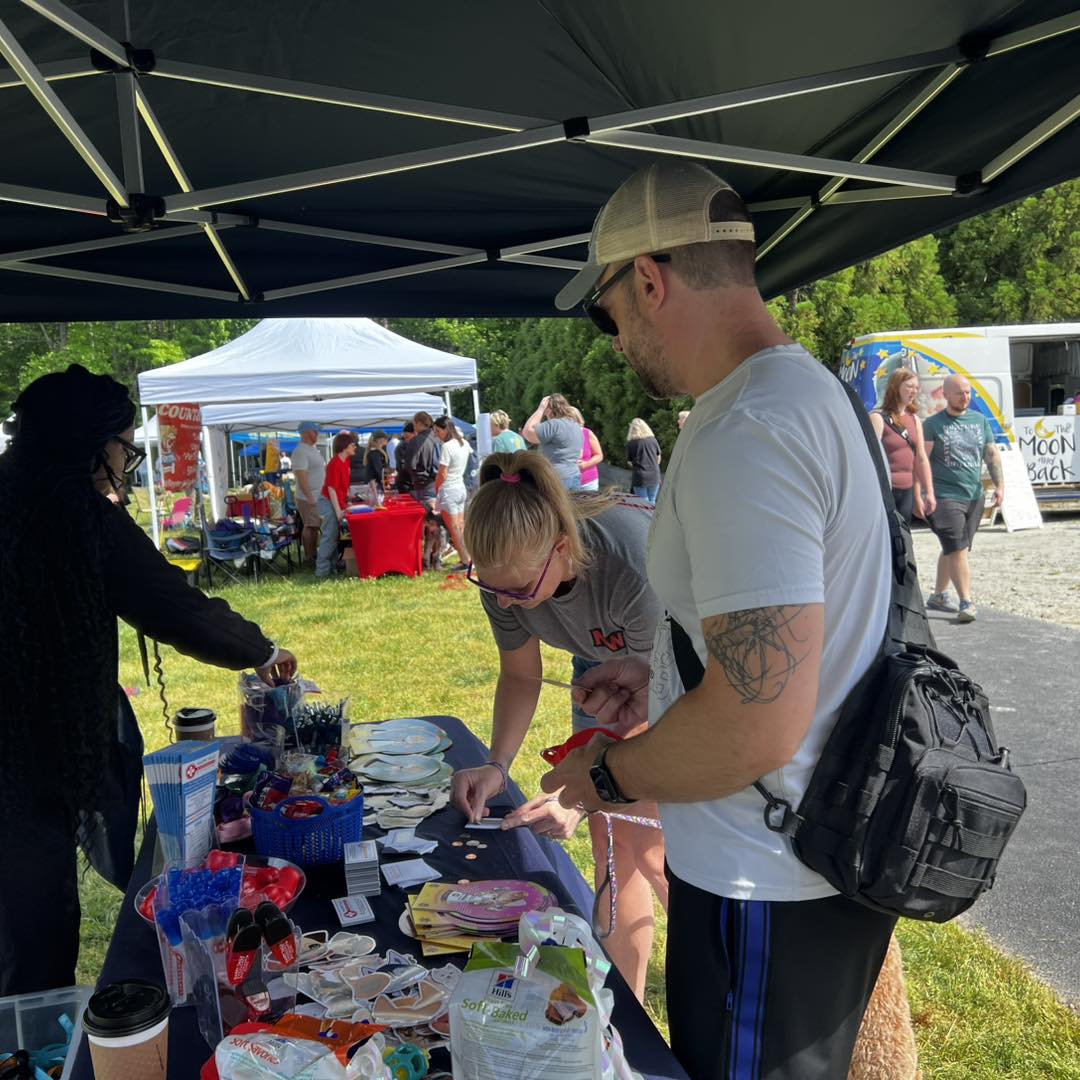female staff member manning outdoor table booth at Bark for Life event